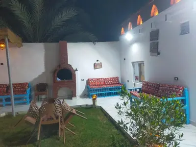 a living room with chairs and a fireplace at Dolphin guest house in Jazīrat al ‘Awwāmīyah