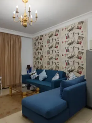 a living room with blue couches in front of a wall at The View in Hurghada