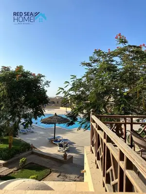 a view of a beach with an umbrella and chairs at Cozy and spacious apartment for family , view sea in Hurghada