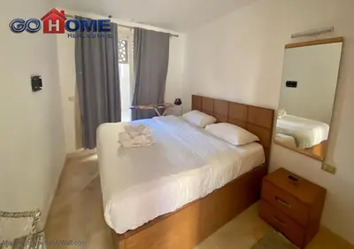 a bedroom with a bed with a flower on it at Stylish 1 Bedroom at Scarab - El-Gouna WS14 in Hurghada