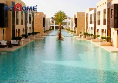a large swimming pool with a palm tree in the middle at Stylish 1 Bedroom at Scarab - El-Gouna WS14 in Hurghada