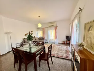 a living room with a table and chairs and a couch at Stunning 2BR Apartment - Al Dora Resort, Hurghada in Hurghada