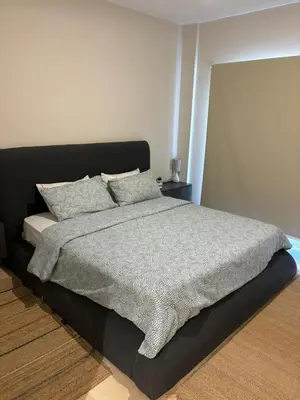 a bedroom with a bed with a gray blanket and pillows at Sea View Haven at Mangroovy in Hurghada