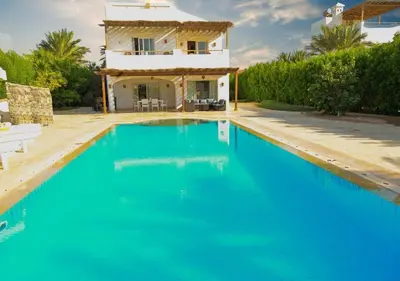 a villa with a swimming pool in front of a house at Stylish 4 BR with a Private Heated Pool V15 at White Villas in Hurghada