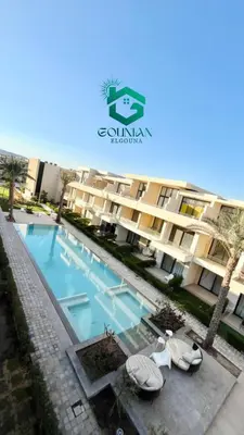 a swimming pool in front of a building at Cozy studio G-cribs in Hurghada