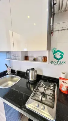 a kitchen counter with a stove and a sink at Cozy studio G-cribs in Hurghada