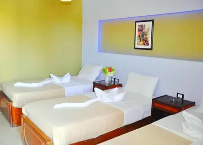 a hotel room with three beds with white sheets at New Geisum Resort in Hurghada