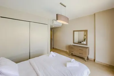 a bedroom with two white beds and a mirror at Radiant & Refined 2BDR MangroovyFree Beach & Pool in Hurghada