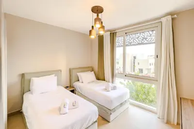 two beds in a room with a window at Radiant & Refined 2BDR MangroovyFree Beach & Pool in Hurghada