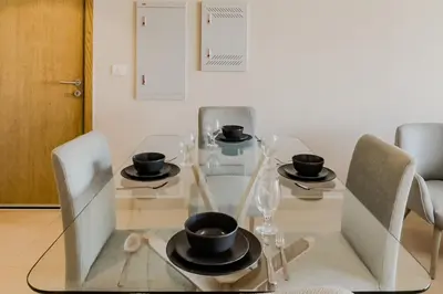 a dining room table with chairs and a glass table top at Radiant & Refined 2BDR MangroovyFree Beach & Pool in Hurghada