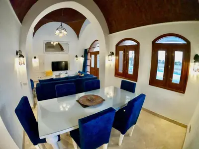 a dining room with a table and blue chairs at Villa 3bedroom in new years in Hurghada