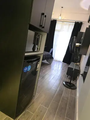 a kitchen with a black refrigerator and a floor at Cozy studio near by the beach - Intercontinental in Hurghada