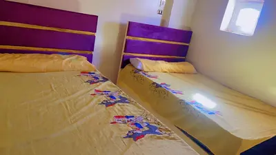two beds sitting next to each other in a bedroom at waleed home in Jazīrat Aswān