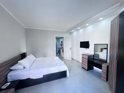a white bedroom with a bed and a desk at سكانديك ريزورت - Scandic resort in Hurghada
