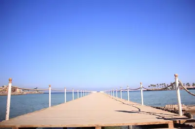 a wooden pier stretches out into the water at سكانديك ريزورت - Scandic resort in Hurghada