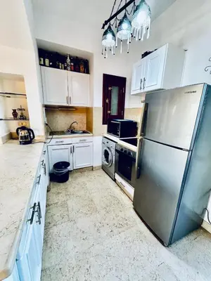 a kitchen with a stainless steel refrigerator and white cabinets at 2Bedroom in west golf in Hurghada