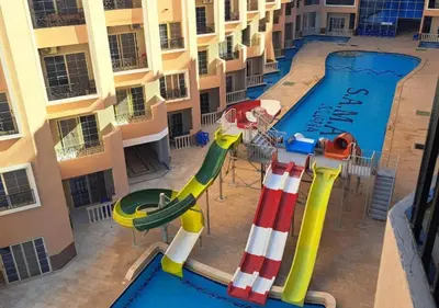 an image of a pool with a water slide at Juliana beach resort in Hurghada