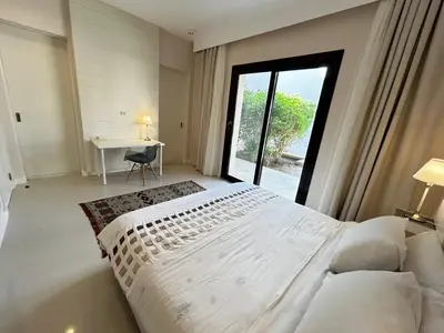 a bedroom with a large white bed and a desk at luxury ancient stands resort one bedroom in Hurghada