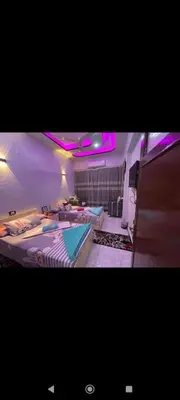 two beds in a room with purple lights at City center NewAswan in Aswan