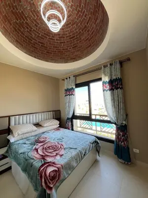 a bedroom with a bed and a large window at Makadi heights - phase 2 in Hurghada