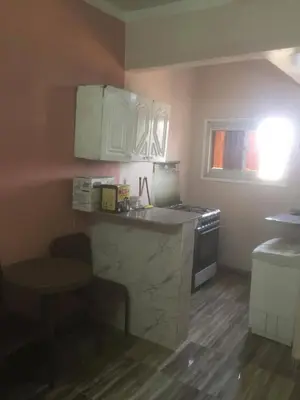a small kitchen with white cabinets and a stove at اسوان كسر الحجر وسط البلد in Aswan