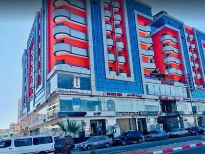 a large building with cars parked in front of it at شقة في موا بلازا كورنيش النيل اسوان Apartment in Mowa Plaza Aswan Nile Corniche in Aswān