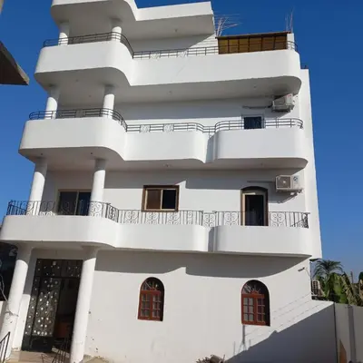 a white building with balconies on it at Banana Guest House in Luxor