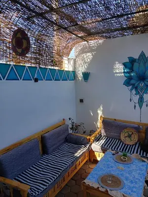 a living room with two beds and a table at Nile Rose Hause in Al Karnak