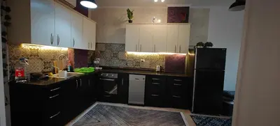 a kitchen with black cabinets and a black refrigerator at Turtles beach resort ED Seaview Apartment in Hurghada