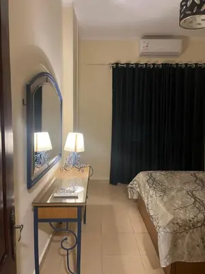 a bedroom with a bed and a table with a mirror at Central Hurghada Apartment in Hurghada