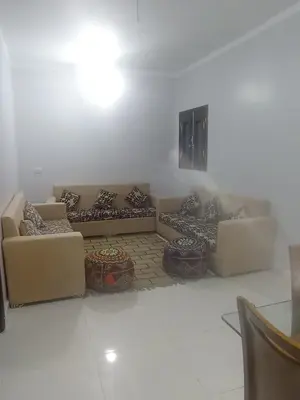 a living room with two couches and two tables at فندق تيم وتميم in Luxor