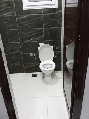 a small bathroom with a toilet and a window at فندق تيم وتميم in Luxor