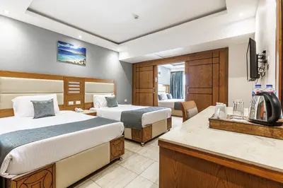 a hotel room with two beds and a television at Sunrise Alora Aqua Park Resort in Hurghada