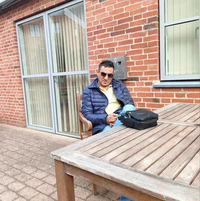a man sitting at a picnic table with a bag at comfort marina 5 apartment,s in Hurghada
