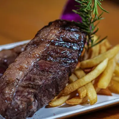 a piece of steak and french fries on a plate at comfort marina 5 apartment,s in Hurghada