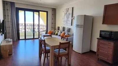 a living room with a table and a refrigerator at Apartment in the view 207 hill view in Hurghada