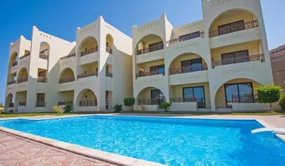 a large building with a swimming pool in front of it at Apartment in the view 207 hill view in Hurghada