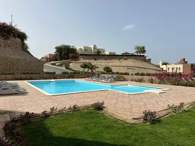 a swimming pool with lounge chairs in a yard at Apartment in the view 207 hill view in Hurghada