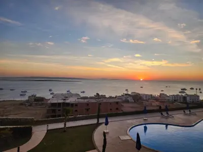 a view of a city and the ocean at sunset at One bedroom in Island View in Hurghada