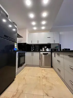 a kitchen with white cabinets and black appliances at One bedroom in Island View in Hurghada