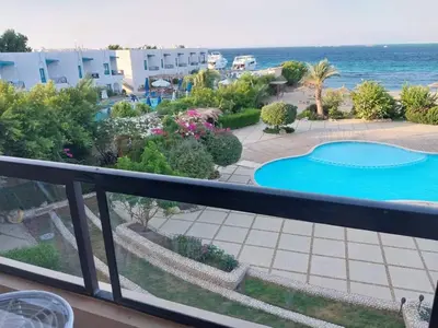 a balcony with a view of a swimming pool and the ocean at Studio for rent 206 in Hurghada
