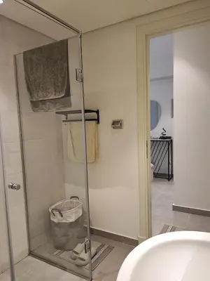 a bathroom with a glass shower with a sink at Soma Breeze Sea and Golf view in Hurghada