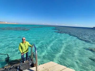 a man standing on the end of a boat in the water at Soma Breeze Sea and Golf view in Hurghada