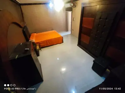 an orange bed in a room with a door at SuperElite apartment NileView F4 in Naj‘ al ‘Amrāb