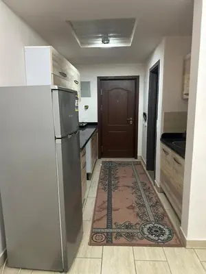 a kitchen with a stainless steel refrigerator and a door at Aldau heights 2 in Hurghada
