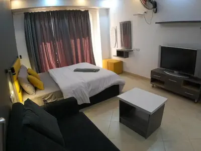 a room with a bed and a tv and a couch at Dive Hostel Hurghada Pool in Hurghada