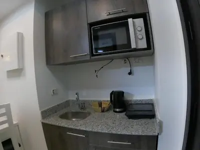 a kitchen with a sink and a microwave at Dive Hostel Hurghada Pool in Hurghada