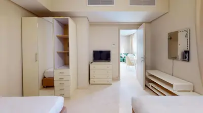 a bedroom with two beds and a tv and a mirror at 2bedroom in mangrove in gouna in Hurghada