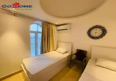 a bedroom with two beds and a clock on the wall at Pretty 4Bedrooms Penthouse MB7 at New Abu Tig Marina in Hurghada