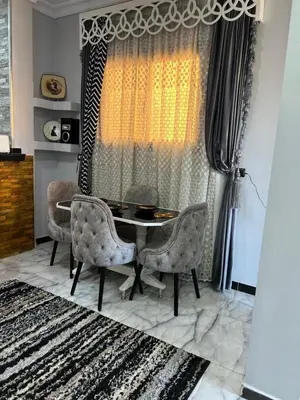 a dining room with a table and chairs and a window at Oscar Apartment 9 in Luxor